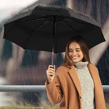 une femme tenant son parapluie sous la pluie